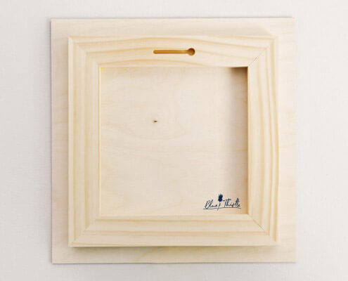 A detailed view of the back of a floatmount wood print, showcasing the recessed 3/4" frame fasten to the print.