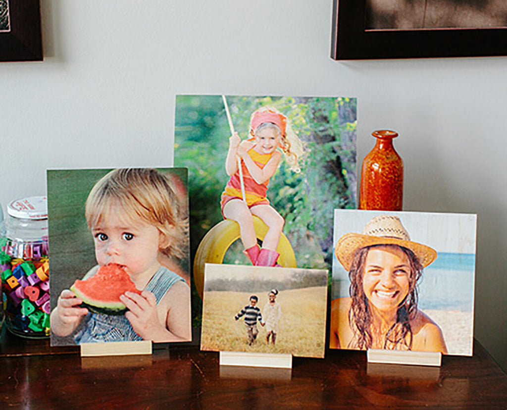 A collection of wood prints in desk stands, positioned on a table