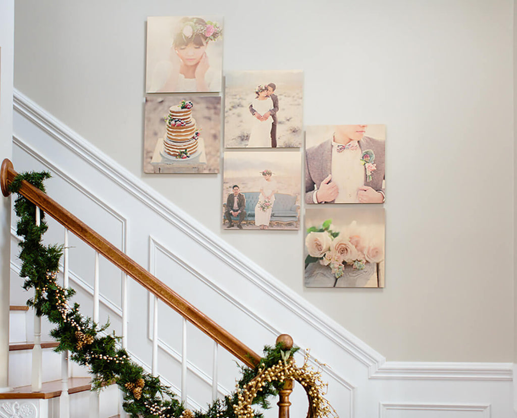 A set of 6 float mount wood photo prints hanging in a grid pattern on a wall above a set of stairs.